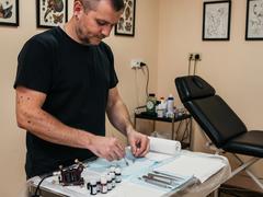 Tattoo artist preparing tools for consultation